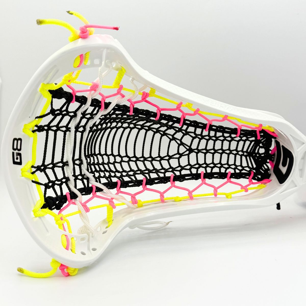 Close-up of a lacrosse head with white, yellow, and pink strings on a white background